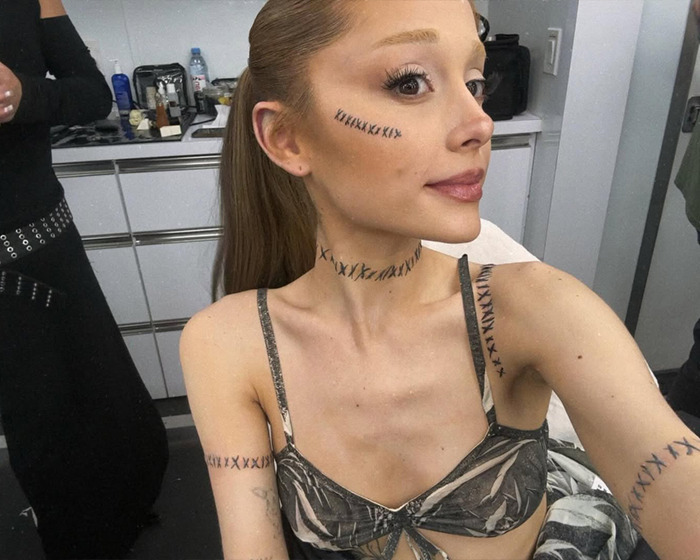 Ariana Grande shows off tattoos and new hairstyle in a stylish outfit.