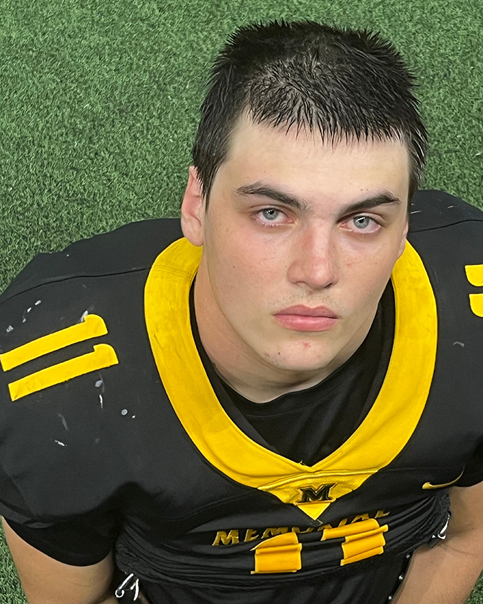 Young athlete in black and yellow football uniform on a grassy field. Young athlete in black and yellow football uniform on a grassy field.