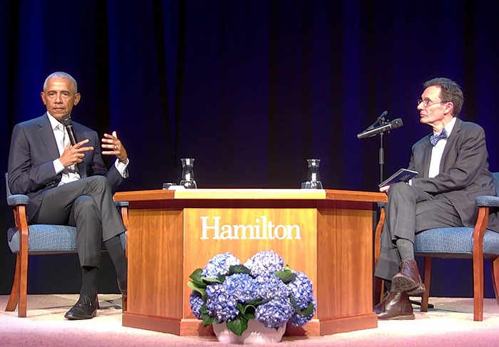 Barack Obama speaking on stage at a Hamilton event, engaging in a discussion about his marriage.