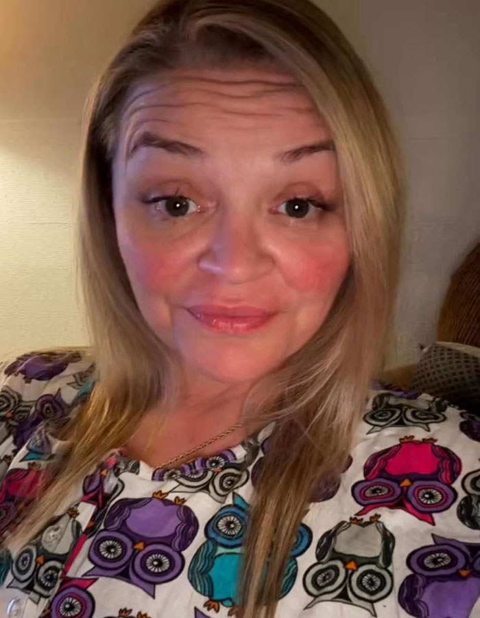 Woman in owl-patterned shirt, smiling in a home setting, related to Tammy Slaton's 500-pound transformation story.
