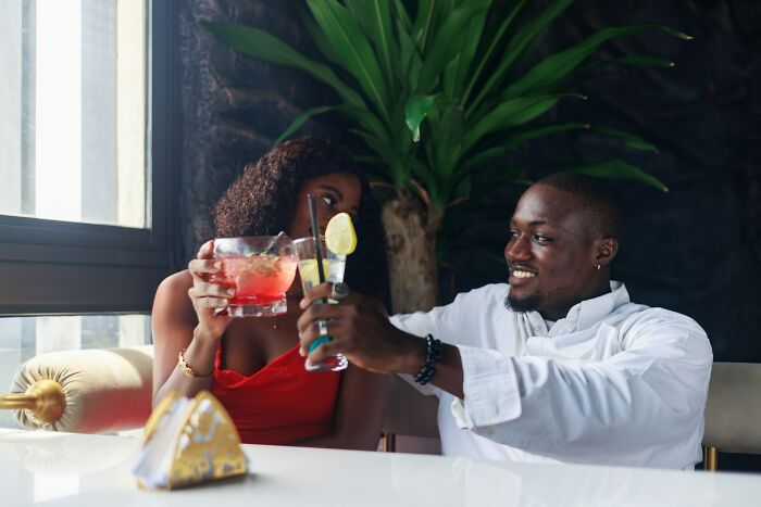 Couple in a relaxed setting with drinks, capturing a moment of joy and reflection on relationship dynamics.