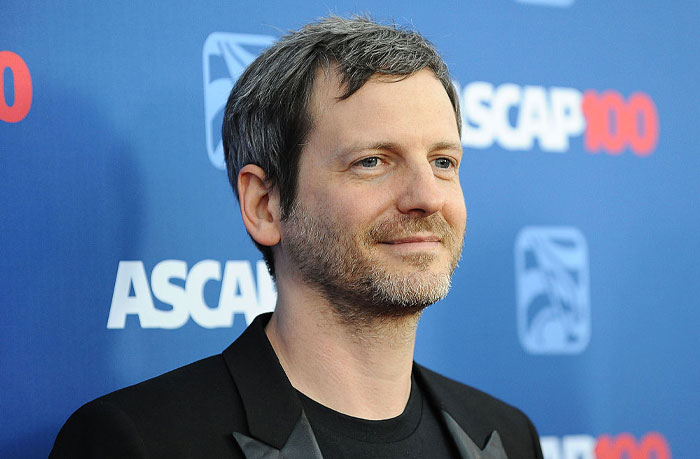 Producer Dr. Luke standing at an event, showcasing successful hitmaker's deep fortune and influence in the music industry.