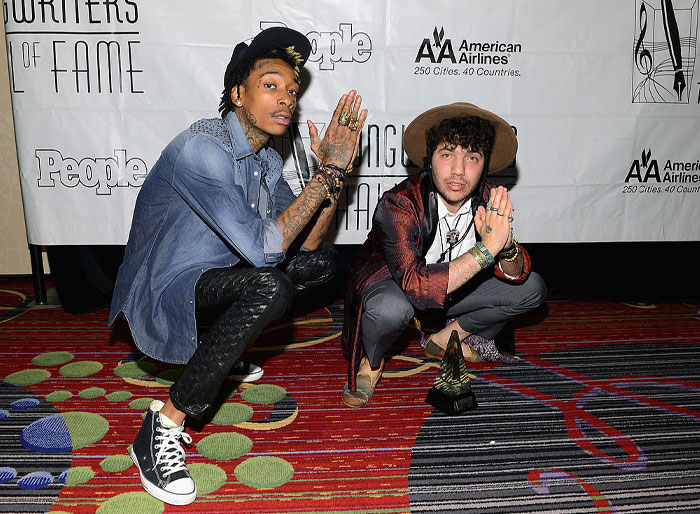 Benny Blanco and Wiz Khalifa posing on a colorful carpet at a music event, associated with Benny Blanco's net worth and success.