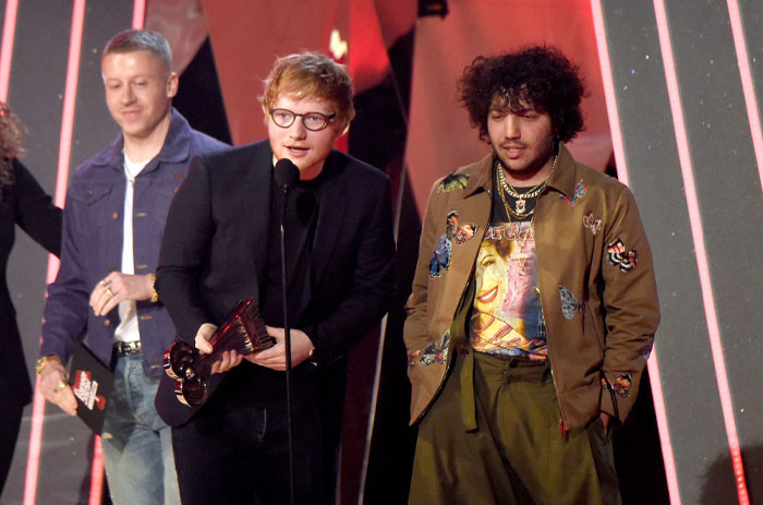 Music producer Benny Blanco onstage with Ed Sheeran at an award ceremony, showcasing his success and impact in the industry.