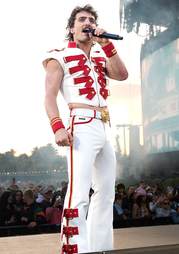 Celebrity in a white and red outfit with a microphone on stage at Coachella 2025.