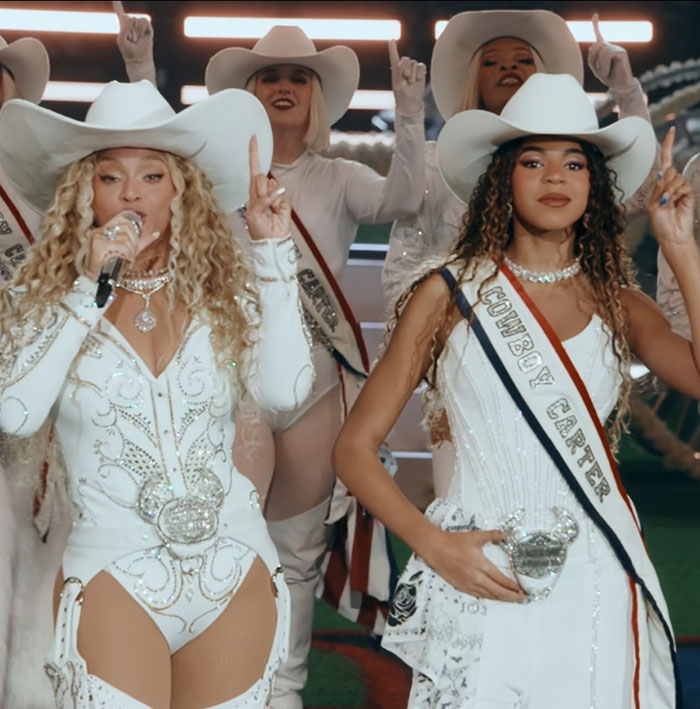 Beyonc&eacute; and Blue Ivy performing live in white cowboy outfits, relating to accusations of grooming involving Jay-Z.