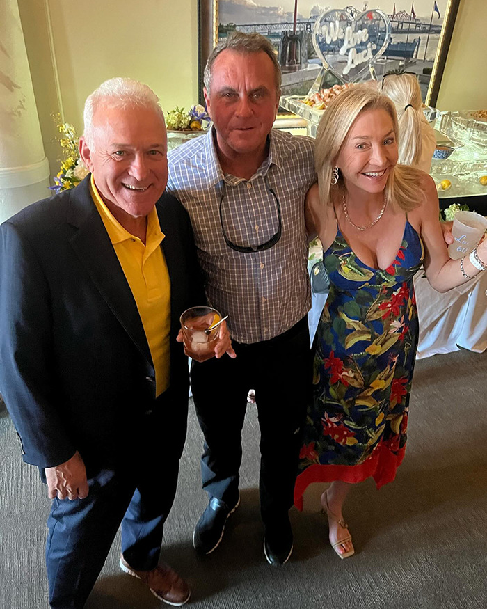 Three people at an event, one in a colorful dress, highlighting restaurant dress code debate.