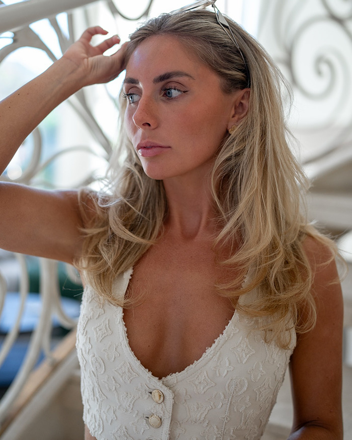 Blonde woman in white top posing indoors with natural light, related to Bonnie Blue escorted from major soccer stadium incident.