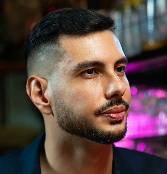 Profile of a thoughtful man with trimmed beard, relating to traders' arrogance being challenged by wealth.