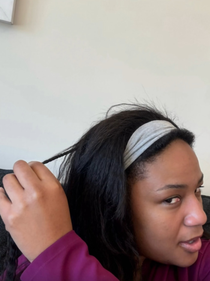 Woman reveals her braided hair, looking surprised after a flight.