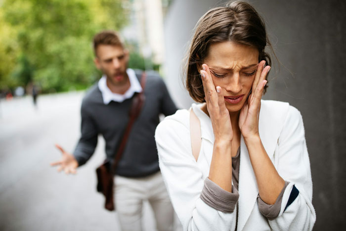A woman looking distressed while a man argues in the background, highlighting a conflict involving CPS accusations.