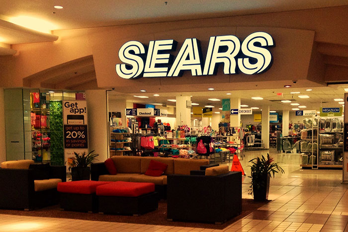 Sears storefront inside a mall with empty seating area, representing companies wrecked by a single bad decision.