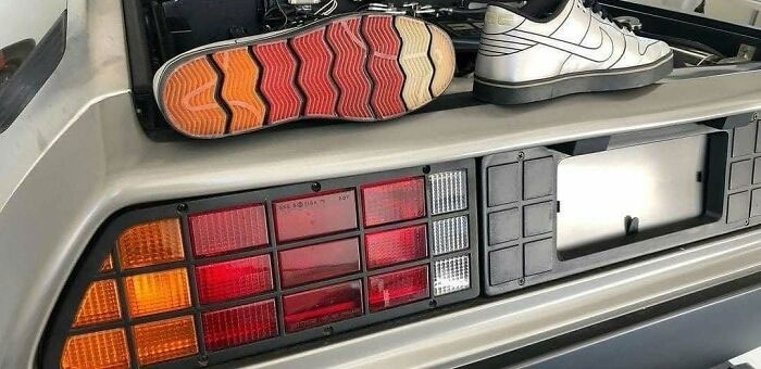 Car meme with sneakers on a vintage car bumper, featuring colorful shoe soles.