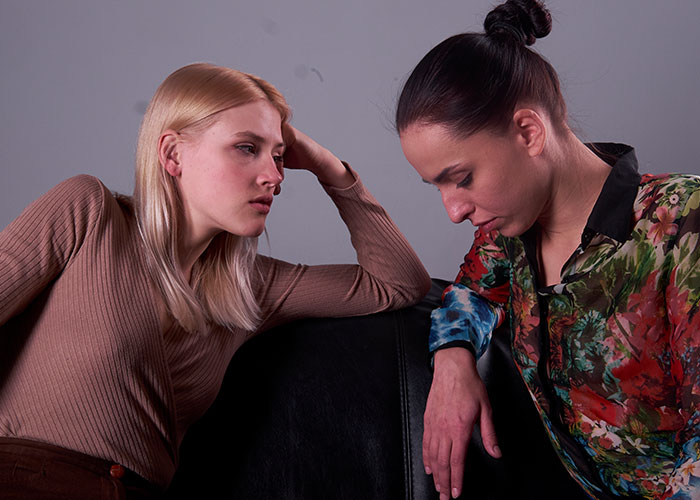 Two women in a serious conversation, reflecting on temptation and relationships.