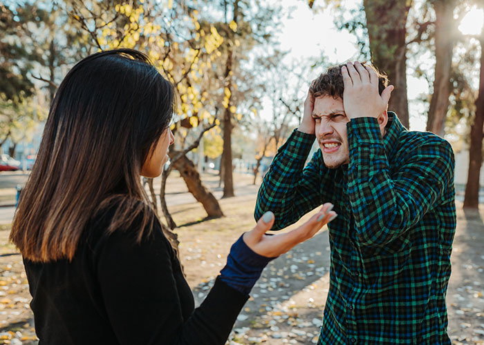 A couple in an intense conversation outdoors, showing frustration and distress about temptation and infidelity.