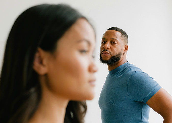 Man in blue shirt looking at woman, illustrating temptation and the drive to cheat.