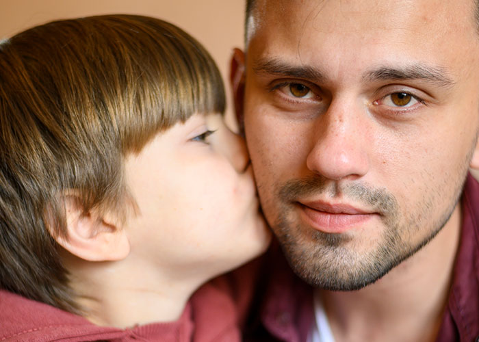 Child whispering to an adult, capturing a tender moment illustrating temptation and connection.