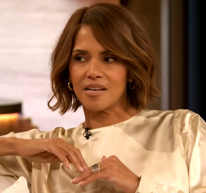 Celebrity in a cream blouse speaking on a talk show, illustrating how talented people can be complex individuals.