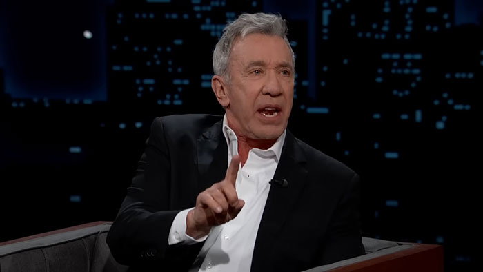 Man in a suit expressing a strong opinion on a talk show, illustrating talented people's capability for complex behavior.