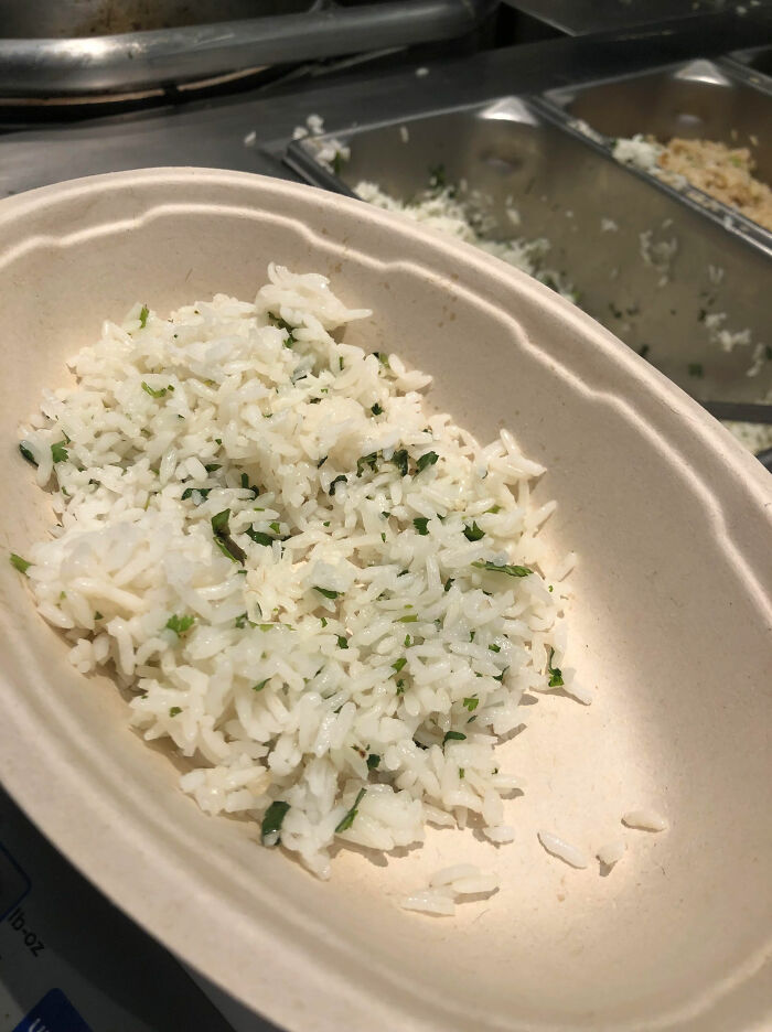 Chain restaurant rice dish with herbs in a brown bowl, ready to serve.