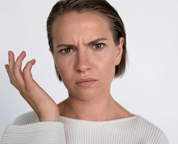Woman with an annoyed expression, representing karma facing a bully after public jokes. Woman with an annoyed expression, representing karma facing a bully after public jokes.