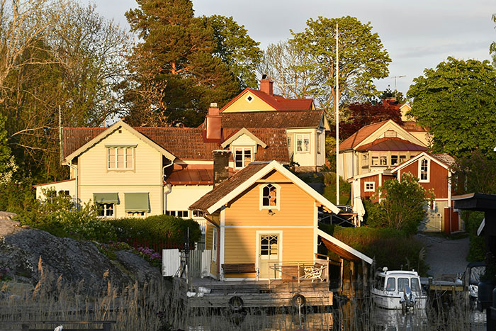 Quaint neighborhood with charming houses lit by sunset, portraying a serene scene of neighborly living. Quaint neighborhood with charming houses lit by sunset, portraying a serene scene of neighborly living.