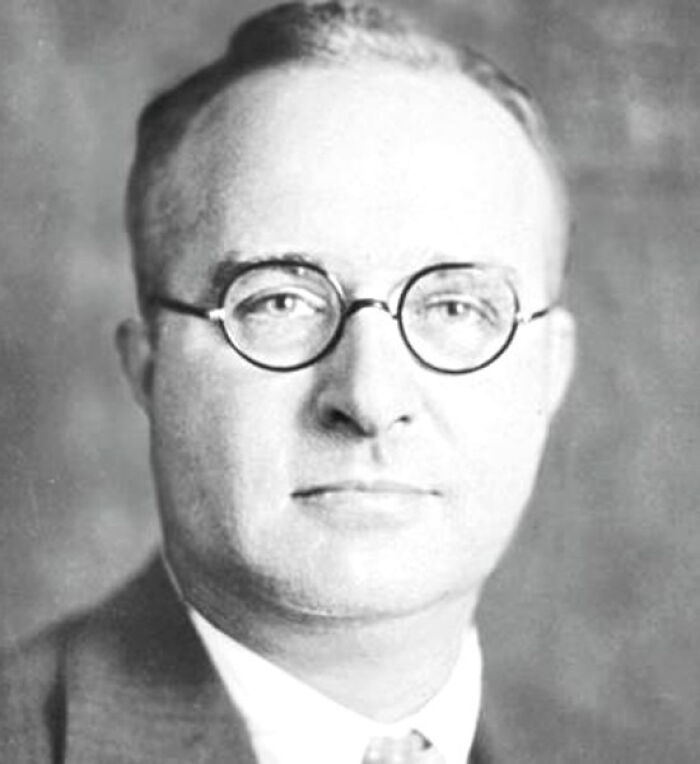 A man in glasses and a suit, representing infamous traitors in history.