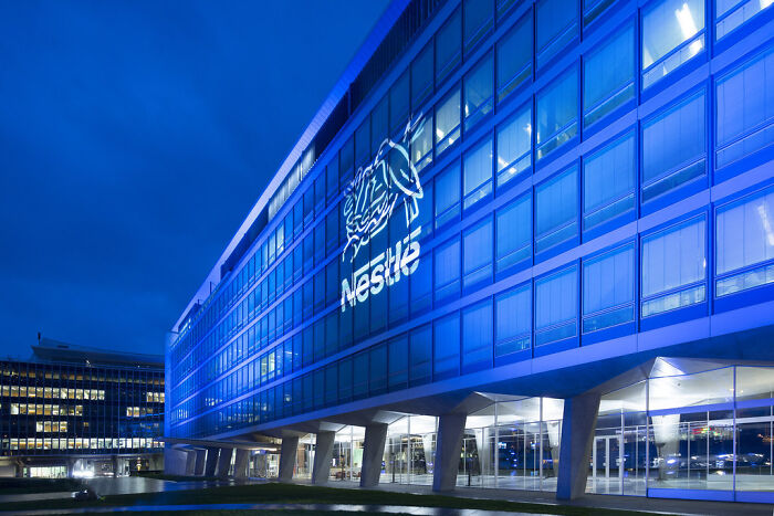 Nestle corporate office building illuminated at night, representing companies that lost customers forever.