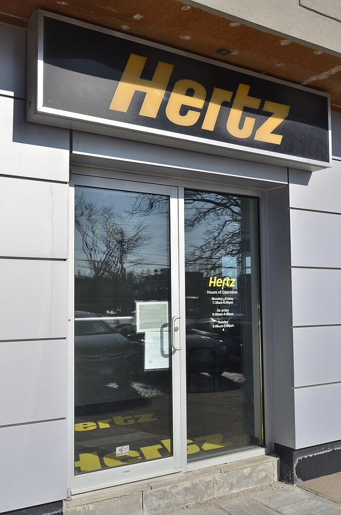 Hertz storefront entrance with logo above glass doors.