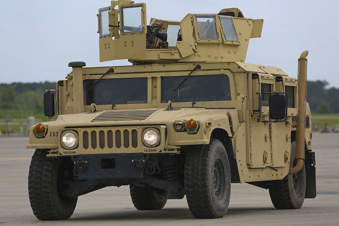 Military vehicle driving on an open road, showcasing unexpected lifesaving features in its design.