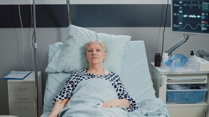 Patient in hospital bed with medical equipment monitoring her vital signs, highlighting concerns doctors often face.