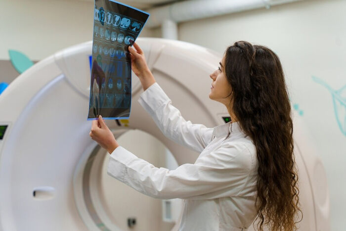 Doctor examining an X-ray image, highlighting common questions they wish friends hadn't asked.