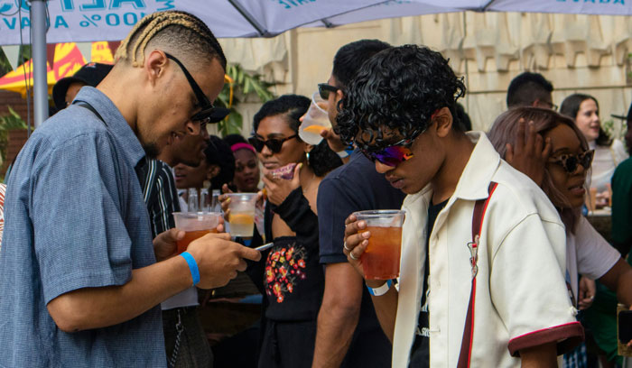 People enjoy drinks at Coachella music festival, reflecting on high food prices.