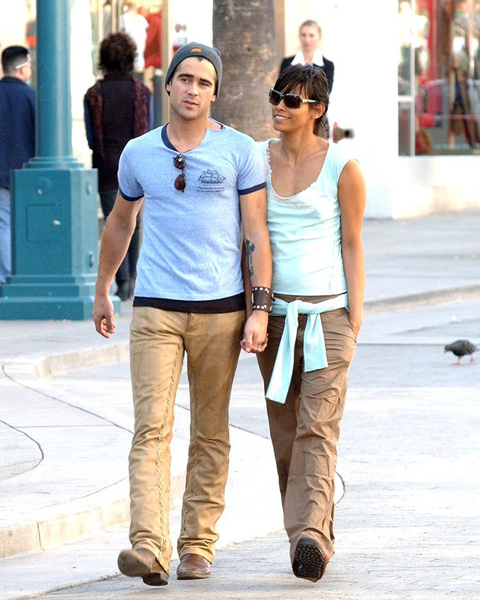 Two people walking outdoors, wearing casual clothing, with sunglasses and hats.