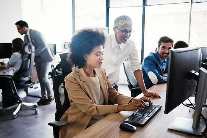 Office employees collaborating at desks, demonstrating work perks and company care.
