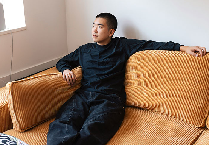 Man relaxing on a mustard-colored sofa, representing work perks showing company care.