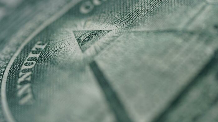Close-up of an eye on a dollar bill, often associated with conspiracy theories.