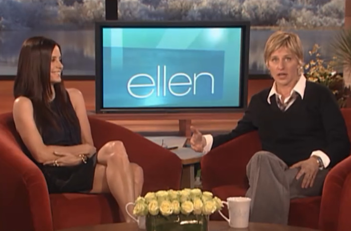 Ellen DeGeneres and Courteney Cox on set during an awkward encounter, seated in red chairs with the show logo in the background. Ellen DeGeneres and Courteney Cox on set during an awkward encounter, seated in red chairs with the show logo in the background.