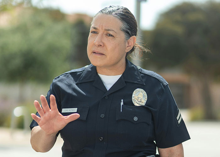 Police officer in uniform gesturing outdoors concerning a neighbor dispute lawsuit. Police officer in uniform gesturing outdoors concerning a neighbor dispute lawsuit.