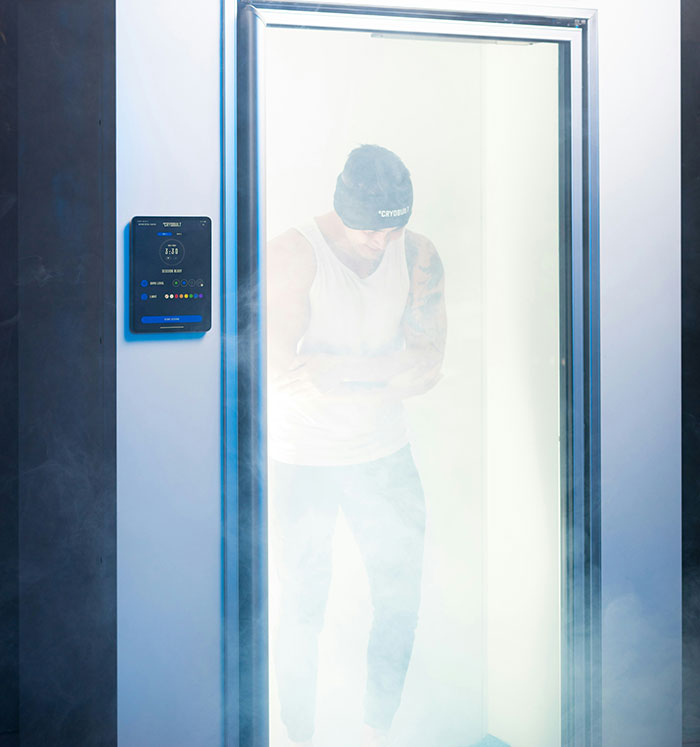 Person inside cryotherapy chamber with steamy mist surrounding, highlighting treatment dangers. Person inside cryotherapy chamber with steamy mist surrounding, highlighting treatment dangers.