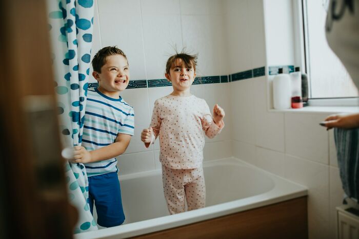 Two kids playing in a bathtub, creating a chaotic but fun moment, highlighting mom sanity challenges.