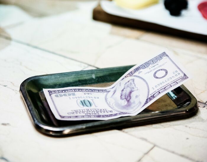 A tip in dollars left on a restaurant table, highlighting American customs.