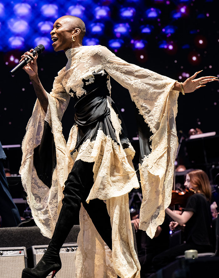 Celebrity in elaborate lace outfit performing at Coachella 2025.