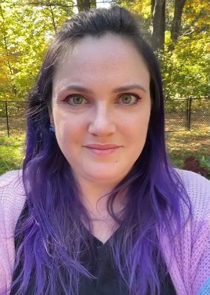 Woman with purple hair in a park, highlighting a dad losing baby at store story.