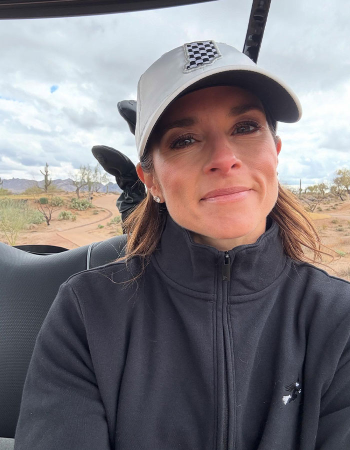 A woman in a black jacket and cap outdoors, commenting on 'woke' Snow White controversy.