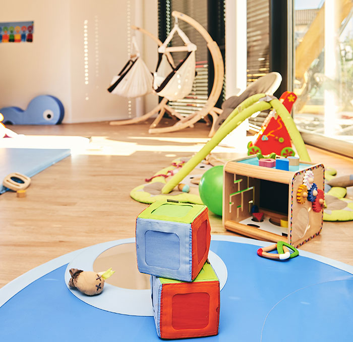 Daycare play area with colorful toys and soft mats, highlighting a space for children to explore and learn.