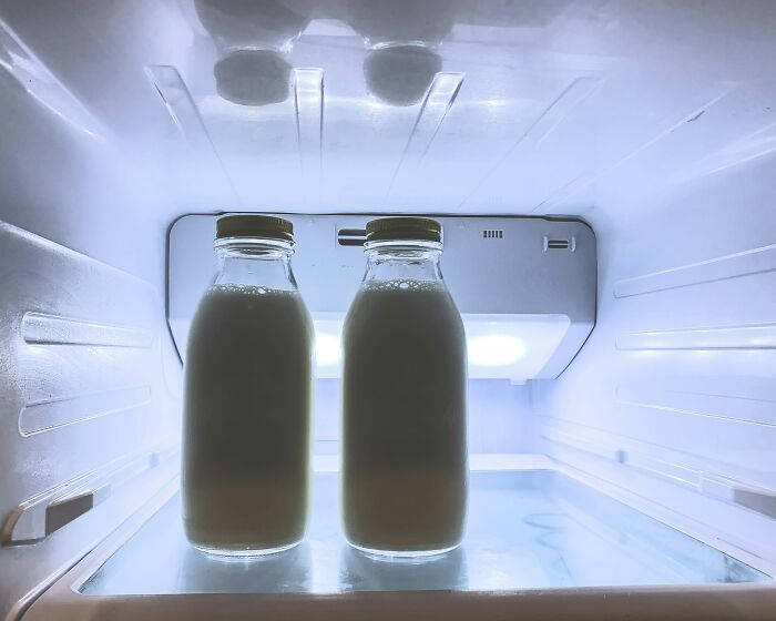 Two glass bottles of milk inside a fridge, illustrating a common cause of relationship arguments and sitcom moments.