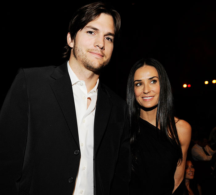 Ashton Kutcher and Demi Moore smiling at a public event in formal attire.