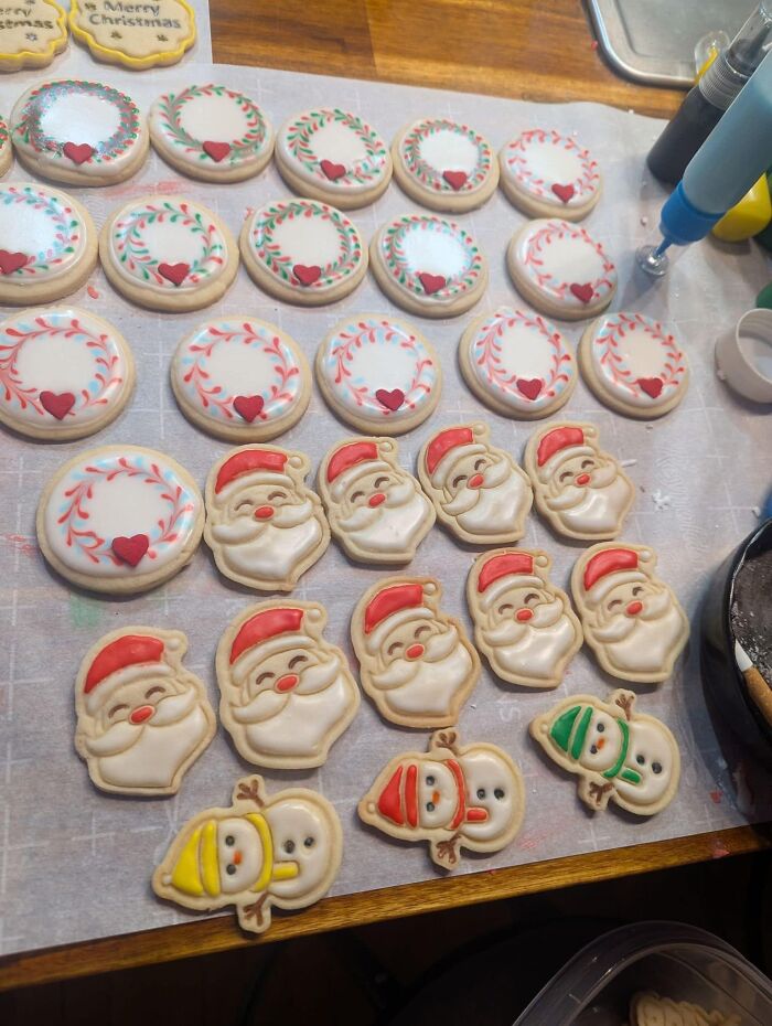Decorated holiday cookies with Santa and wreath designs, served at a potluck.