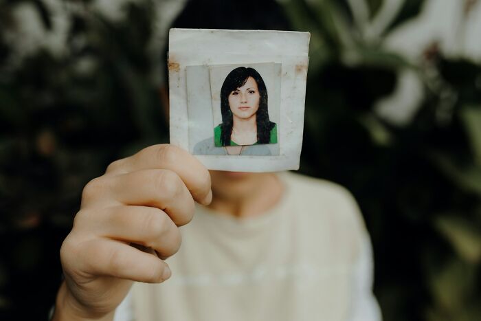 A woman holding a photograph of another woman, highlighting common things women feel embarrassed about.